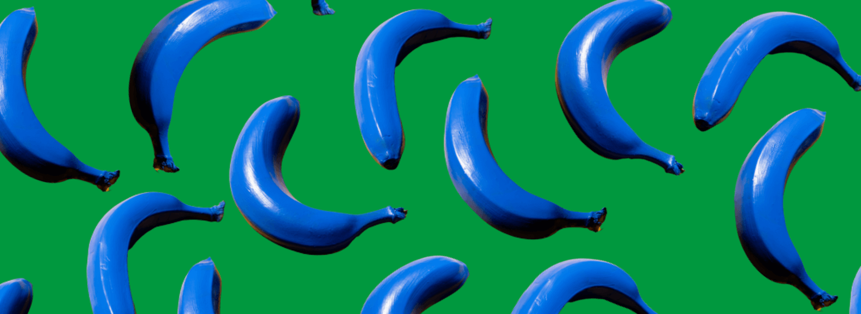 Mehrere blaue Bananen freigestellt auf grünem Hintergrund